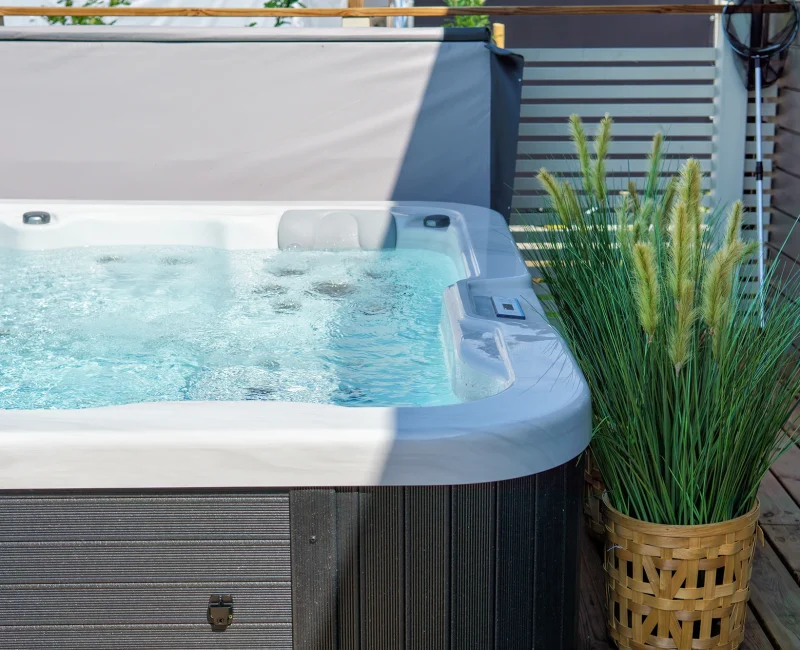 A full outdoor hot tub in garden space.