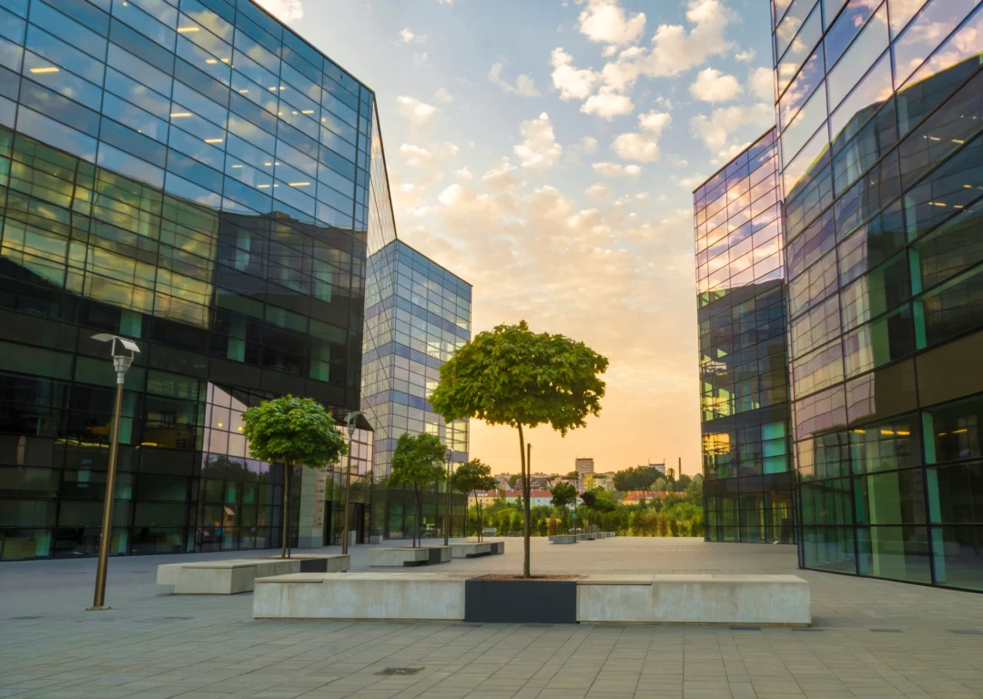Modern office buildings with clean tidy courtyard and evening sky.
