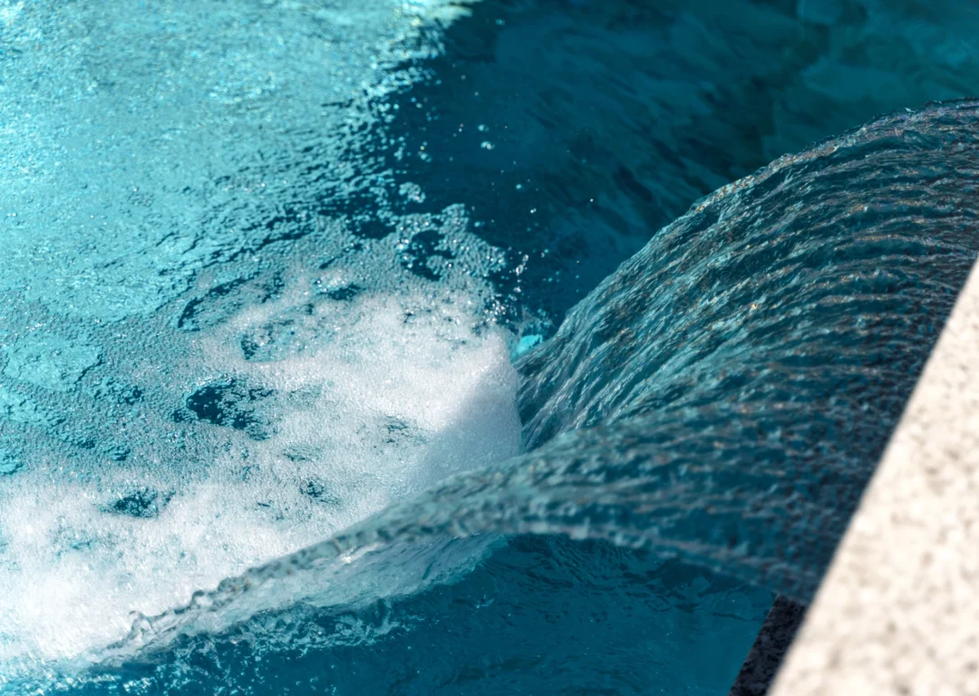 Closeup of swimming pool waterfall on a sunny day.